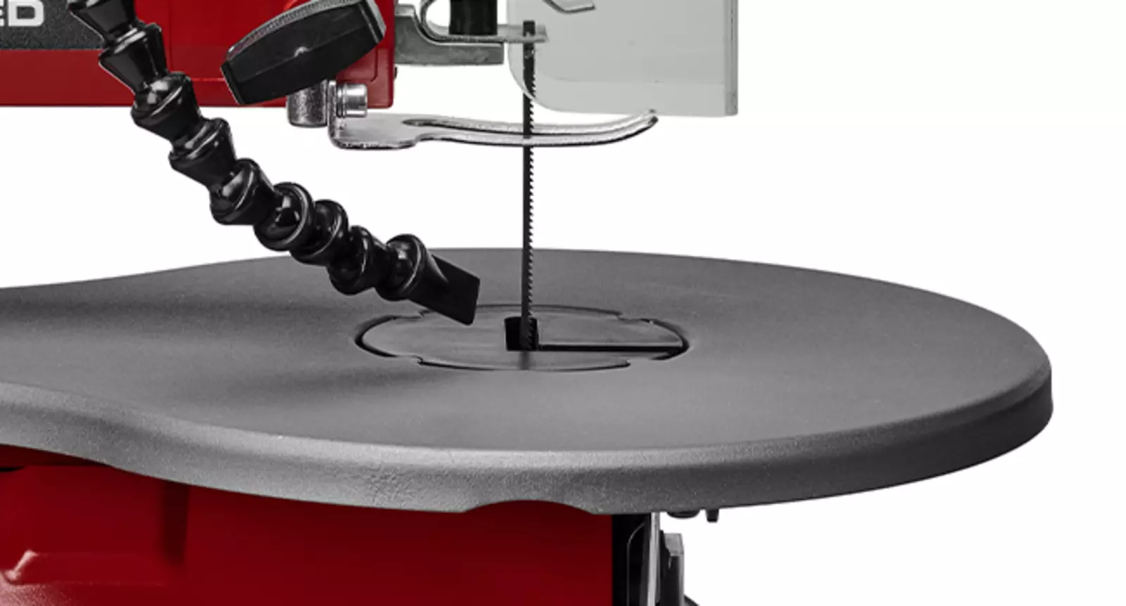 Primer plano del dispositivo de soplado de la sierra de marquetería Einhell TC-SS 406 E sobre la mesa de trabajo.