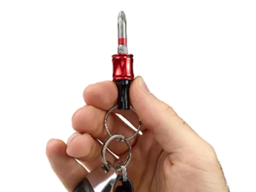 Hand holding a red and black Einhell bit keyring with quick-change function and inserted bit.