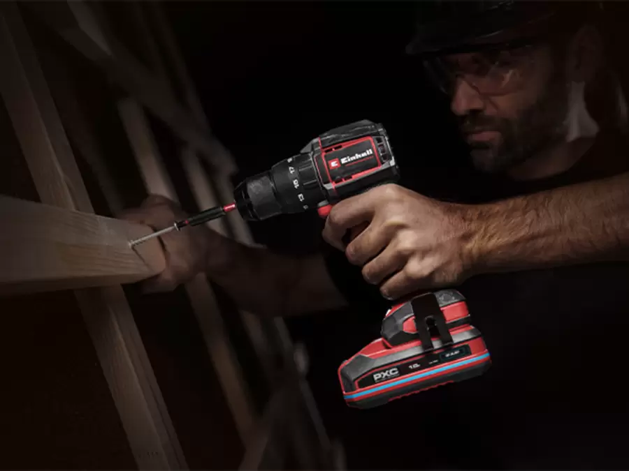 The Einhell Cordless Impact Drill Driver TP-CD 18/70-C Li-i BL - Solo in use in a dark environment with LED light activated.