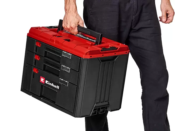 Person carrying the Einhell Pro System Drawer using the integrated ergonomic carry handle.