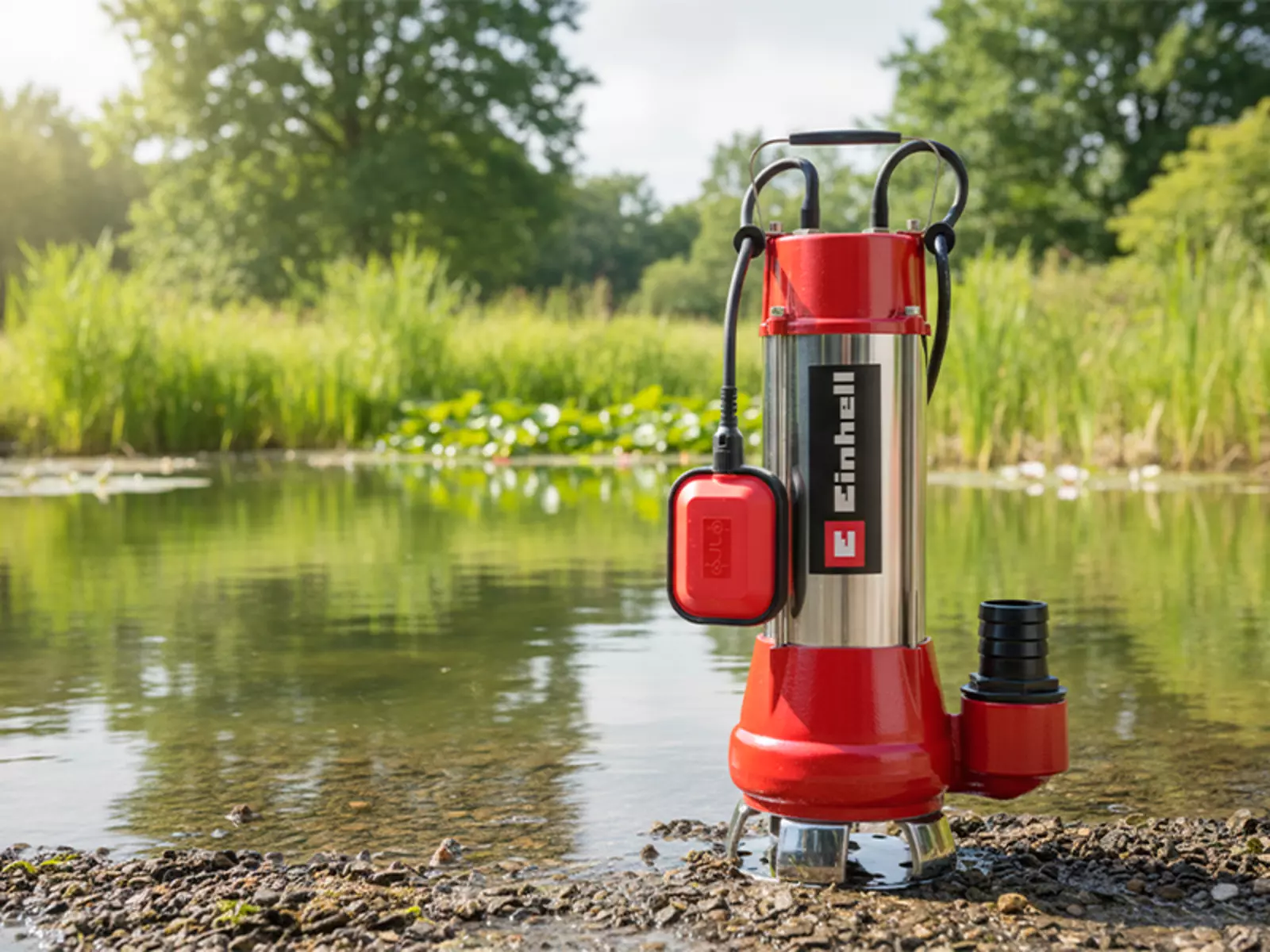 The Einhell dirt water pump GC-DP 1340 G stands on the edge of a pond and is ready for use.