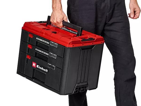 A person carries the Einhell drawer case using the built-in handle.