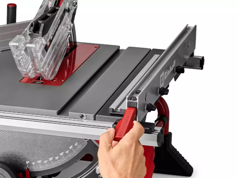 A hand adjusts the parallel stop on the saw table of the Einhell cordless table saw TE-TS 36/10 T Li - Solo.