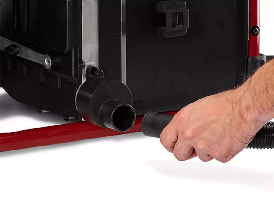 A hand connects a hose to the extraction connection on the Einhell cordless table saw TE-TS 36/10 T Li - Solo.