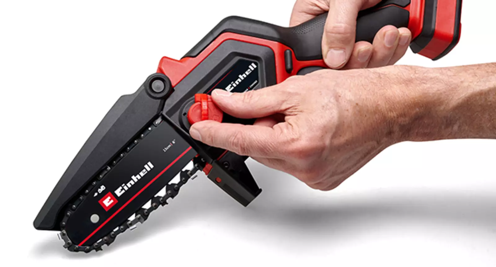 L’image montre des mains qui tendent la chaîne de l’élagueuse sans fil Einhell GE-PS 18/15 Li BL sans outil.