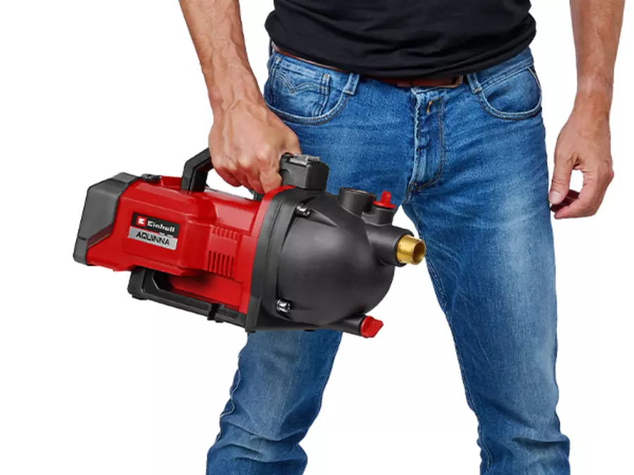The Einhell cordless garden pump AQUINNA 36/30 Set being carried by a person using the handle.