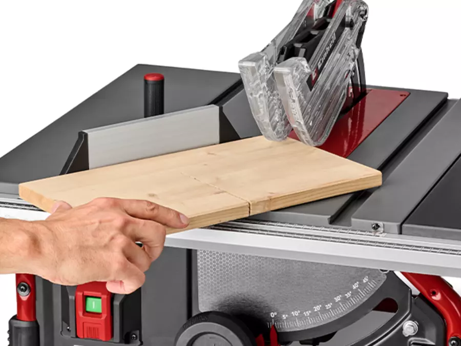 A wooden board is guided over the Einhell cordless table saw TE-TS 36/10 T Li - Solo using the angle stop.