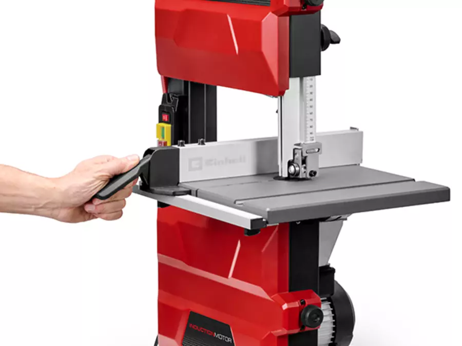 One hand adjusts the parallel guide on the Einhell band saw TC-SB 245/1 L.