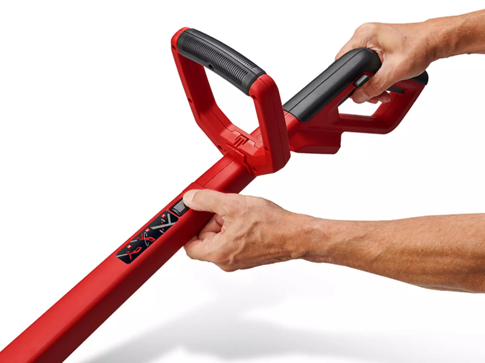 Two hands hold the handle of the Einhell GC-CT 18/2411 Li P cordless trimmer, while one hand presses the button to rotate the Motor head.