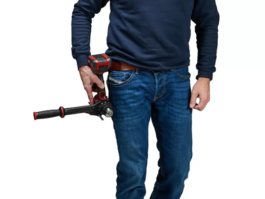 Ein Mann befestigt den Einhell Akku-Schlagbohrschrauber mit dem Gürtelclip an seiner Hose.