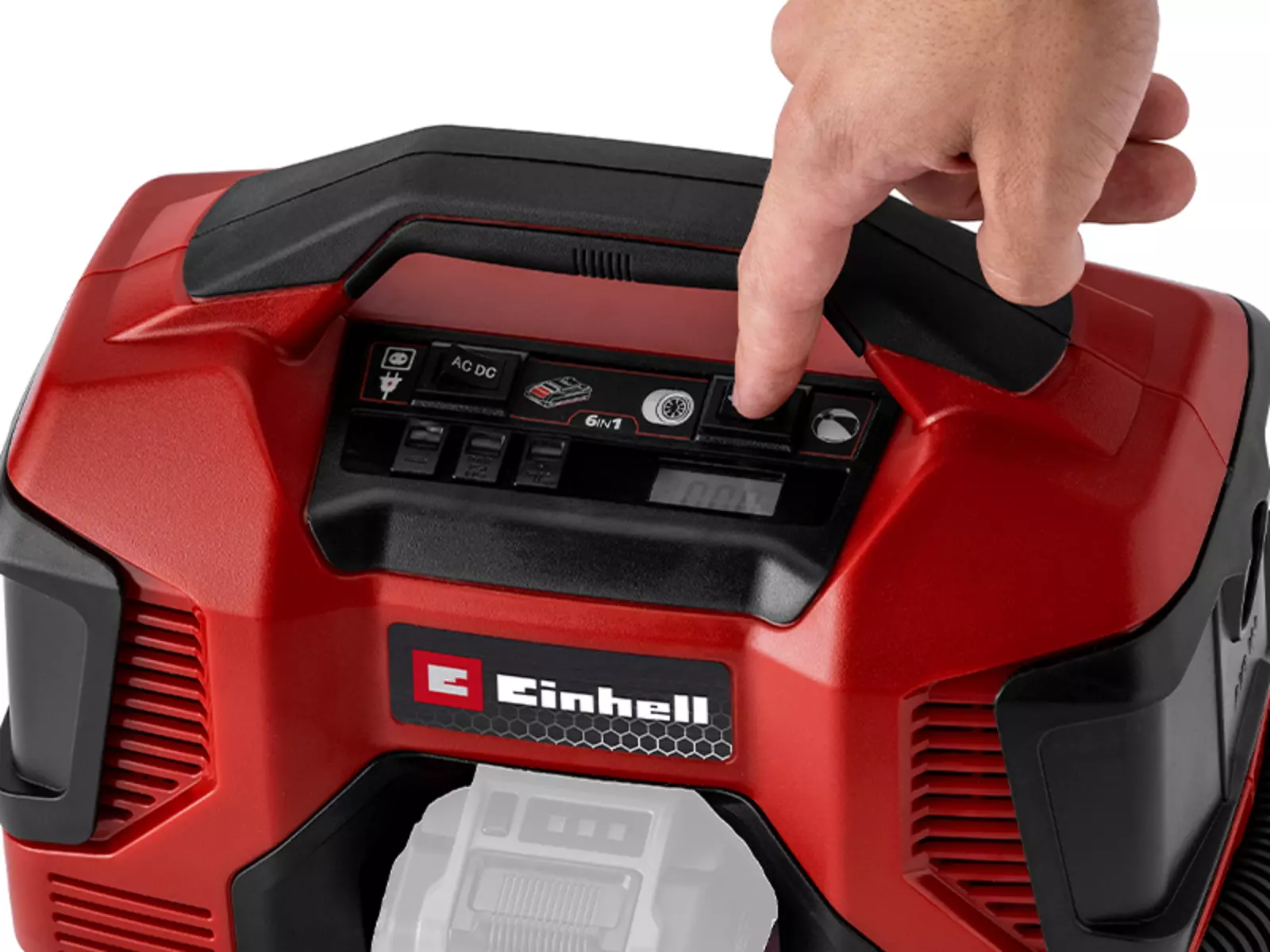 Nahaufnahme der Oberseite des Einhell Akku-Kompressors TC-AK 18 Li - Solo mit Tragegriff. Eine Hand drückt auf eine Taste im Bedienfeld mit der Beschriftung „6in1“, daneben Symbole für AC/DC, Bluetooth und weitere Funktionen.