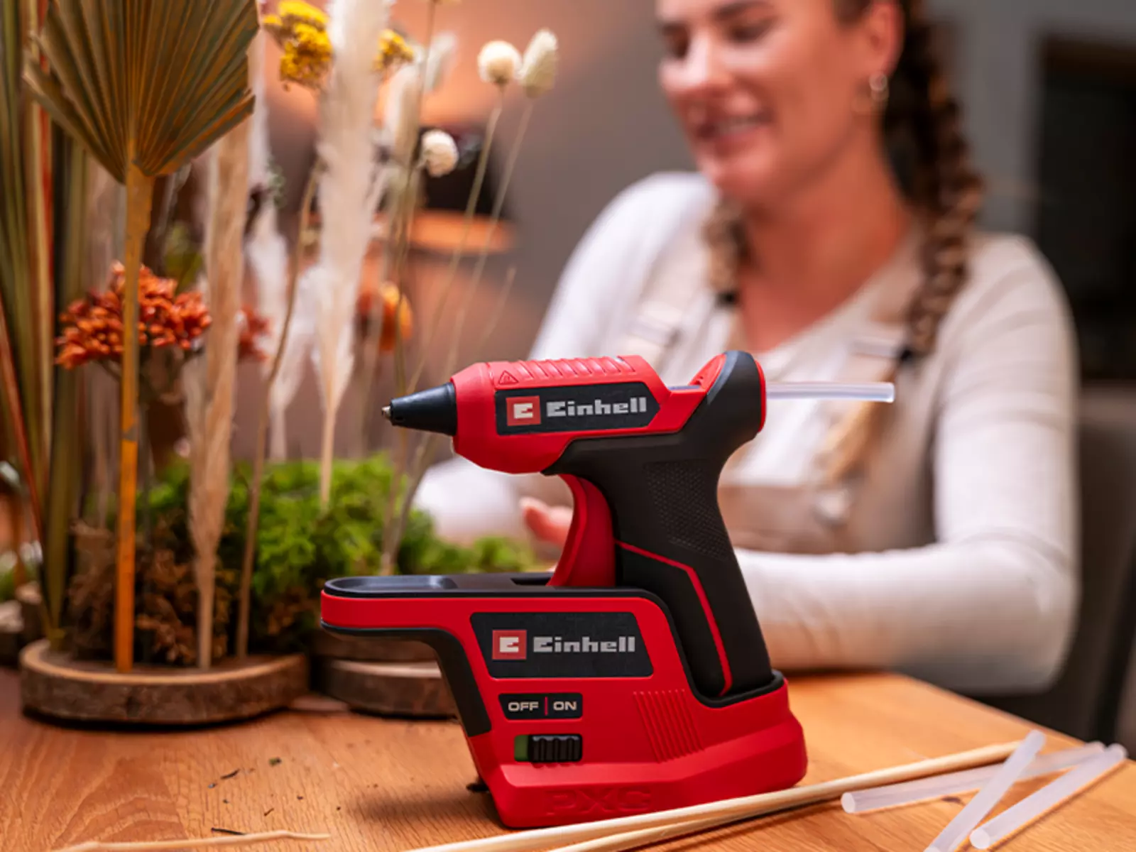 The Einhell cordless hot glue gun TE-CG 18/7 Li in the base station with practical drip tray.