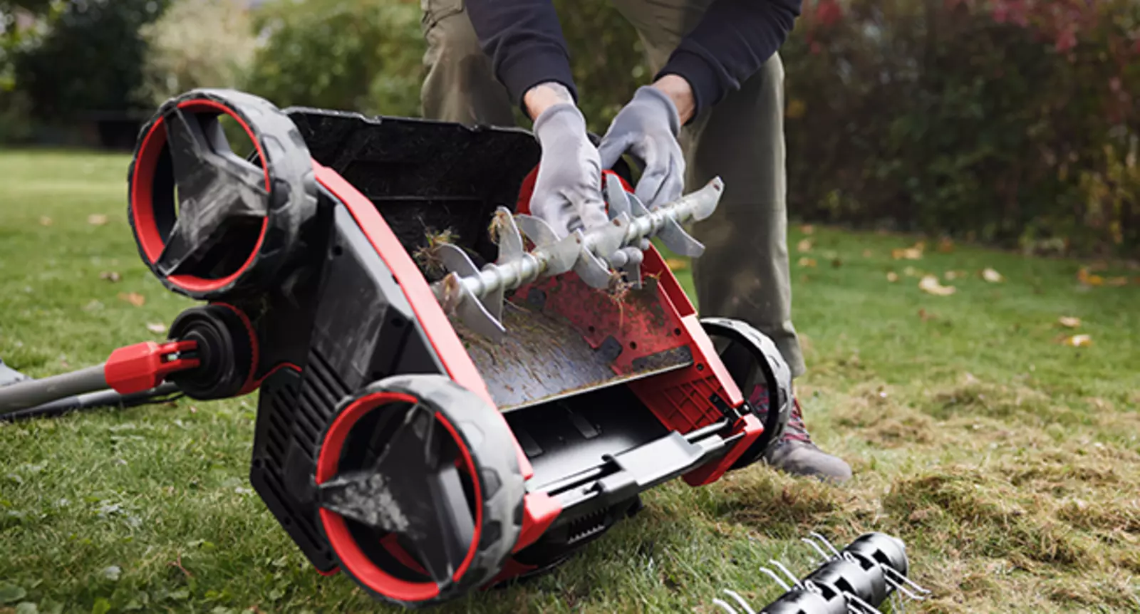 Der Einhell Akku-Vertikutierer-Lüfter GP-SA 36/40 Li BL-Solo beim werkzeuglosen Wechsel der Walze, Gerät auf die Seite gekippt.