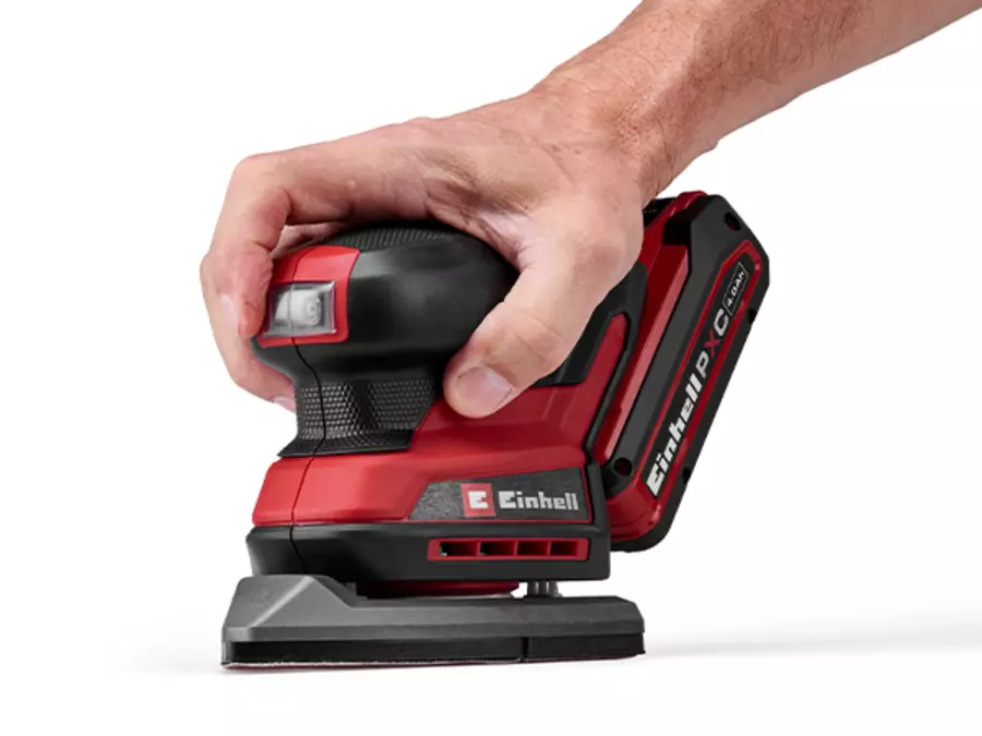 The Einhell cordless multi sander TE-OS 18/150-2 Li is held in one hand on a white background.