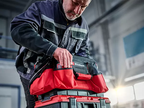 Person accessing tools from the open Einhell Pro System Tool Bag during use.