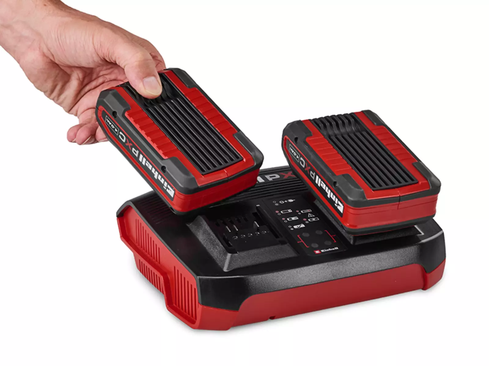 Eine Hand setzt einen Akku in das Einhell Ladegerät Power X-Twincharger 4A ein; ein zweiter Akku ist bereits eingesetzt.