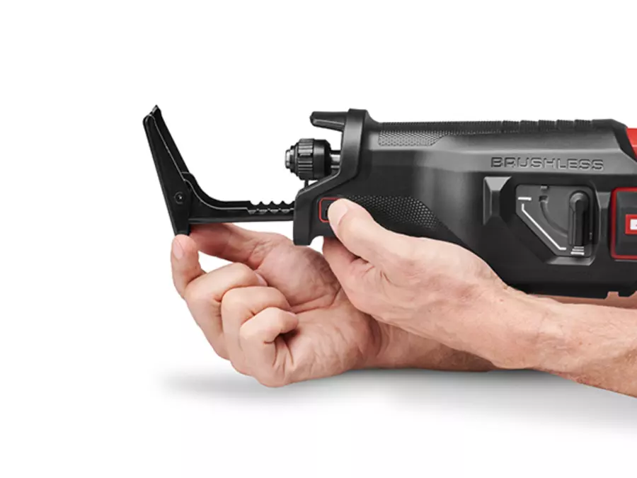 One hand adjusts the soleplate on the Einhell cordless universal saw TP-AP 18/32 Li BL - Solo.