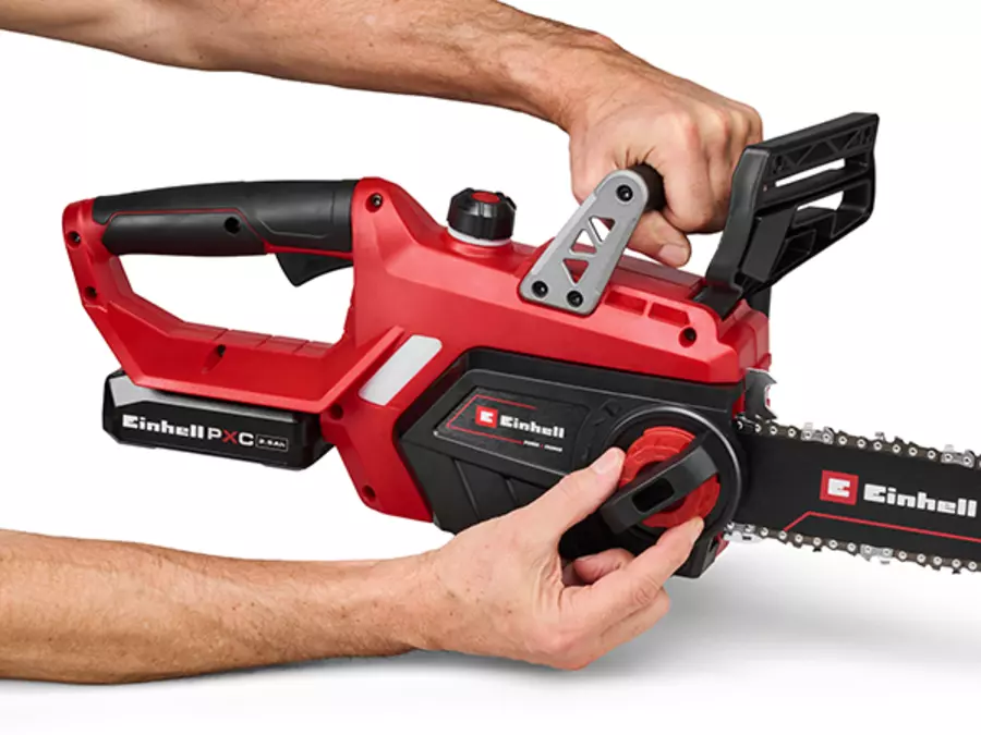 Die Einhell Akku-Kettensäge GE-LC 18/25-1 Li Kit (1x2,5Ah) mit werkzeugloser Kettenspannung; eine Hand stellt die Kette ein.