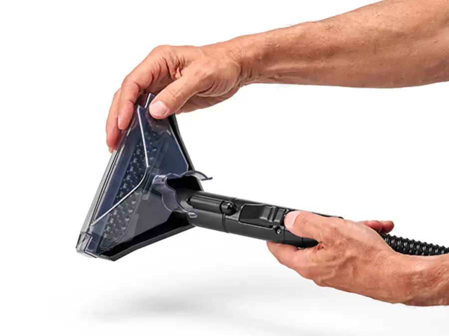 Hände setzen den Aufsatz zur automatischen Schlauchreinigung auf die breite Waschbürste des Einhell Akku-Waschsaugers TE-SCL 18/1100 Li-S BL-Solo.