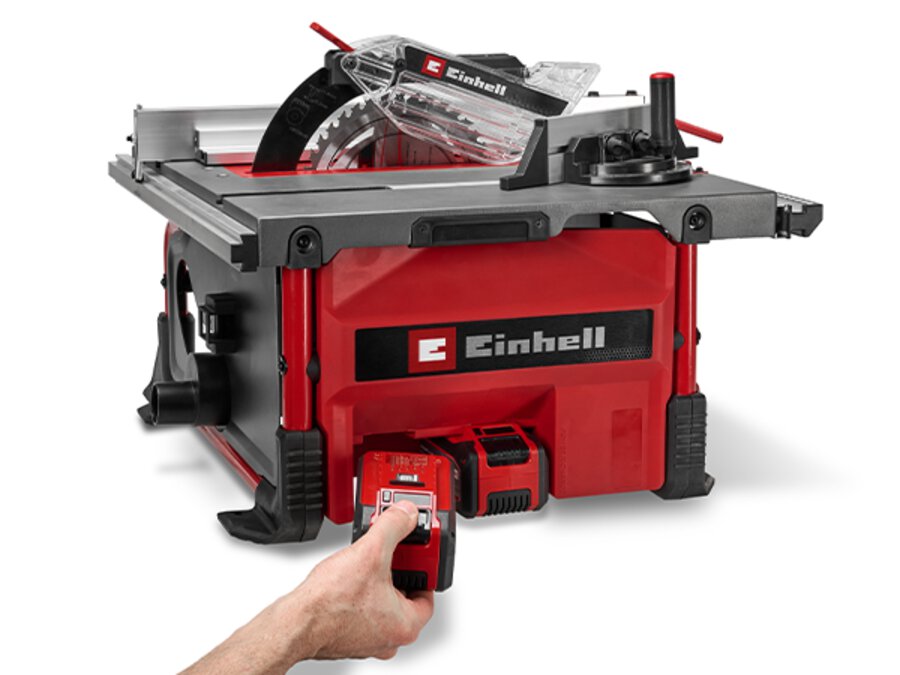 Die Einhell Akku-Tischkreissäge TE-TS 36/8 T Li-Solo von vorne; eine Hand setzt zwei Akkus in das Gerät ein (Twin-Pack-Betrieb).