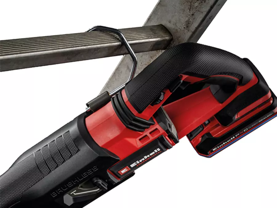 The Einhell cordless universal saw TP-AP 18/32 BL BREAKER Kit hooked onto a metal pipe using the rafter hook.