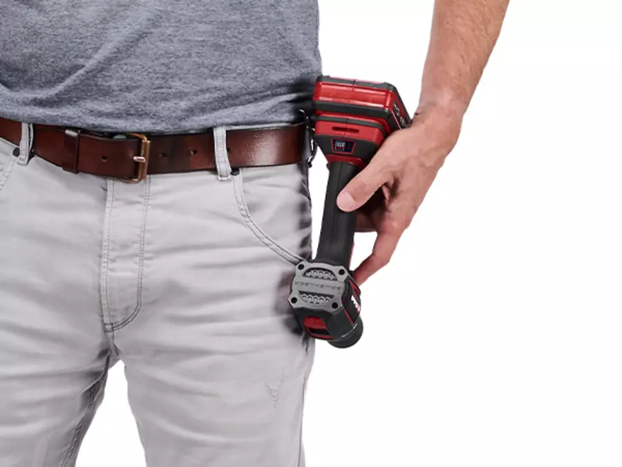 A man with gray trousers wears the Einhell Professional cordless impact drill TP-CD 18/50-C Li-i BL on the belt clip.