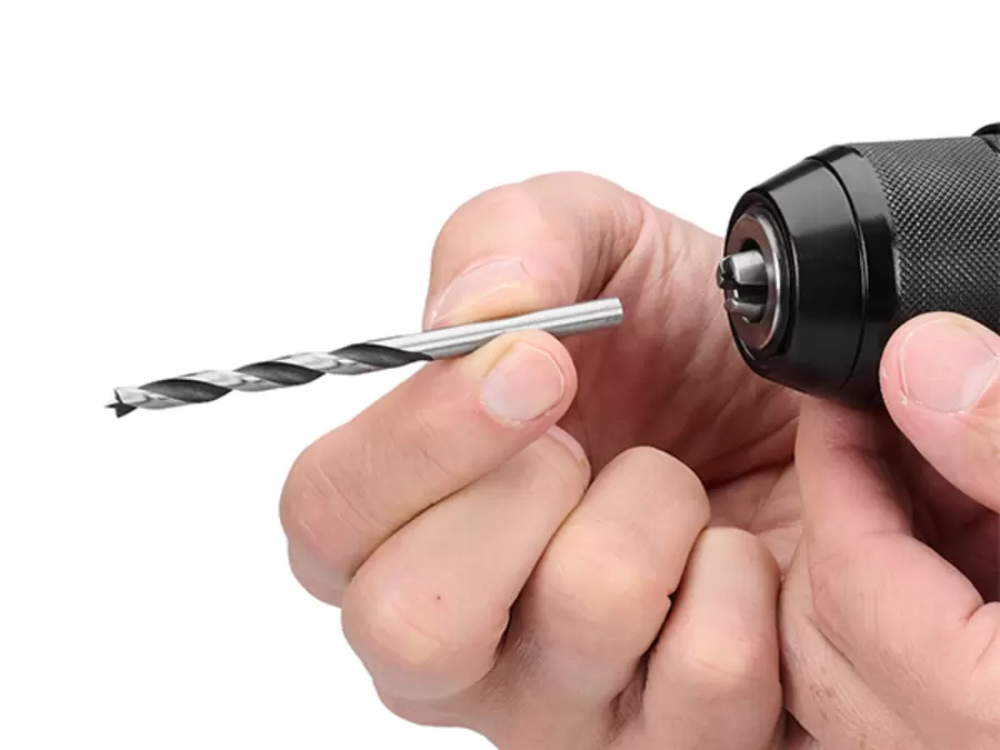 A person inserts a drill bit into the 13 mm keyless chuck of the Einhell Professional Cordless Impact Drill Driver TP-CDD 18/501-C Li-i +70 (3Ah).