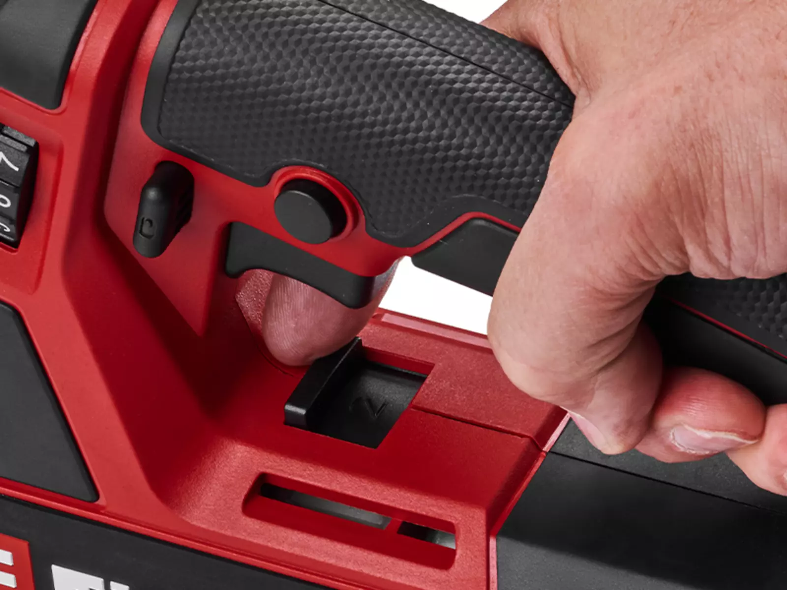 The close-up shows a hand operating the switch on the Einhell cordless grease gun TP-GR 18/690 Li - Solo to switch between two speeds.