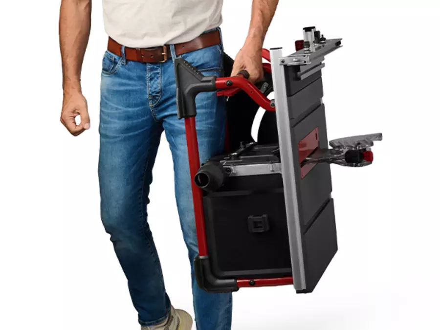 One person carries the Einhell cordless table saw TE-TS 36/10 T Li - Solo using the integrated handle.