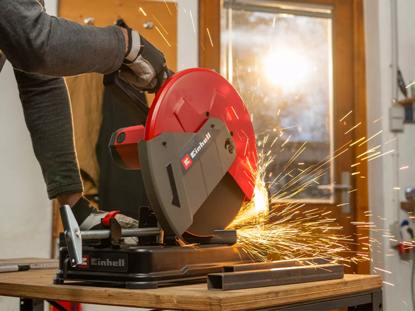 The Einhell metal cutting machine TC-MC 355 in action; sparks fly as a piece of metal is cut.