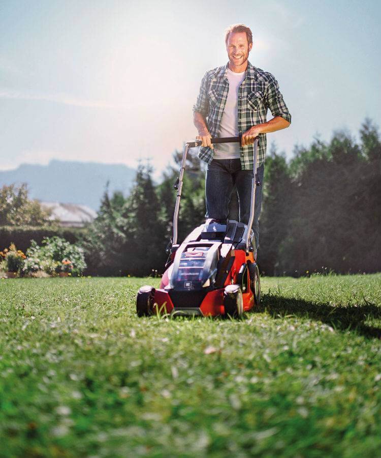 Spare parts for garden equipment – Man mowing the lawn with an Einhell lawnmower