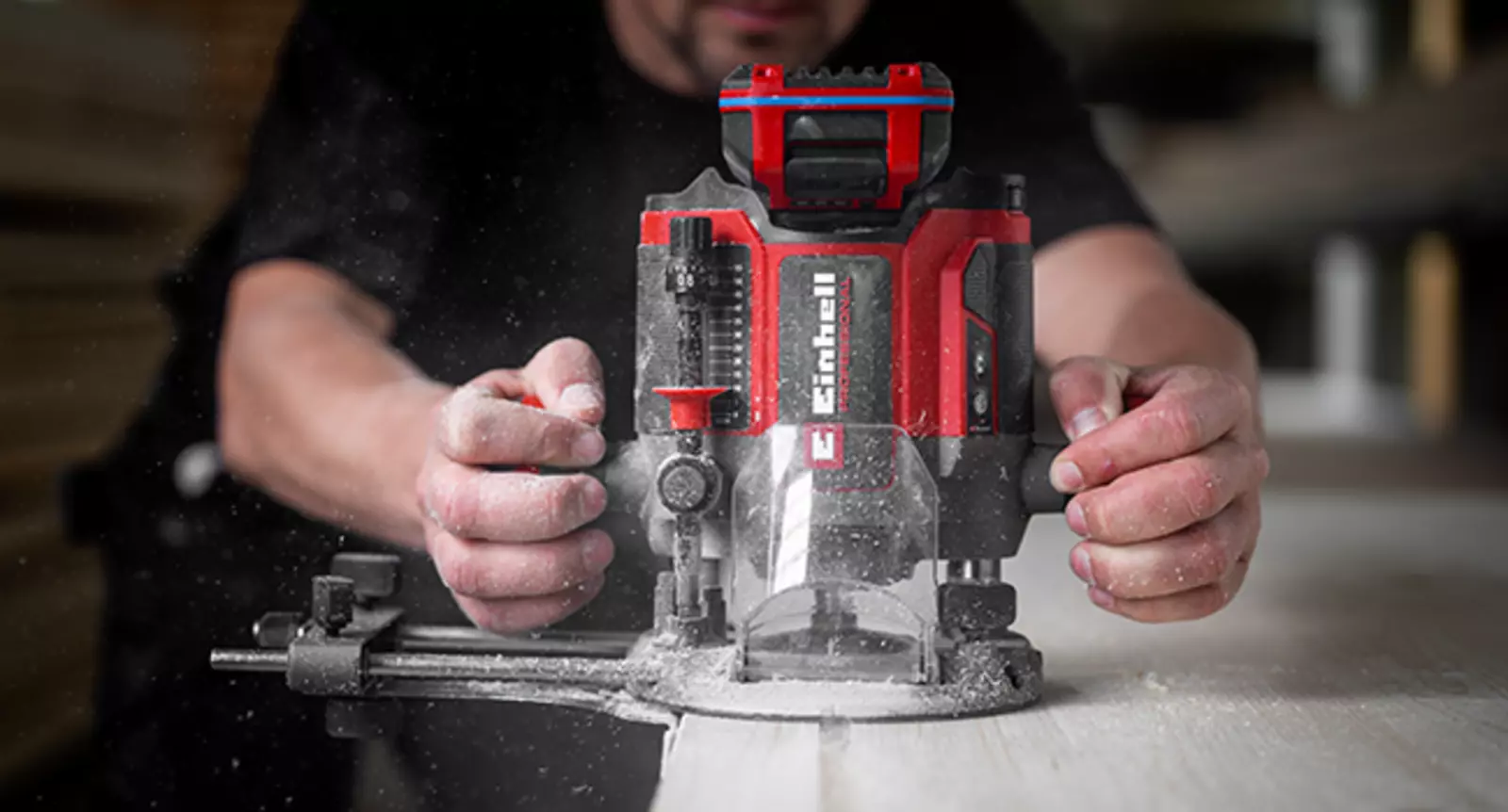 Die Einhell Akku-Oberfräse TP-RO 18/55 Li BL - Solo mit montiertem Parallelanschlag auf einer Holzplatte.