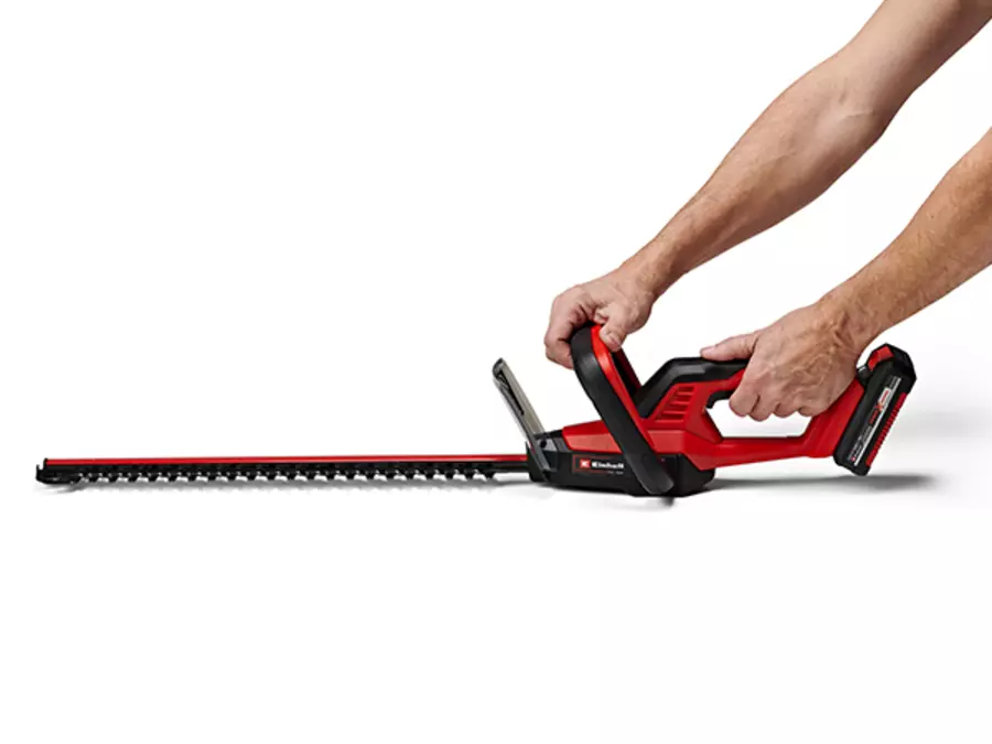 The Einhell cordless hedge trimmer GC-CH 18/40 Li Kit with large front handle is held with both hands.