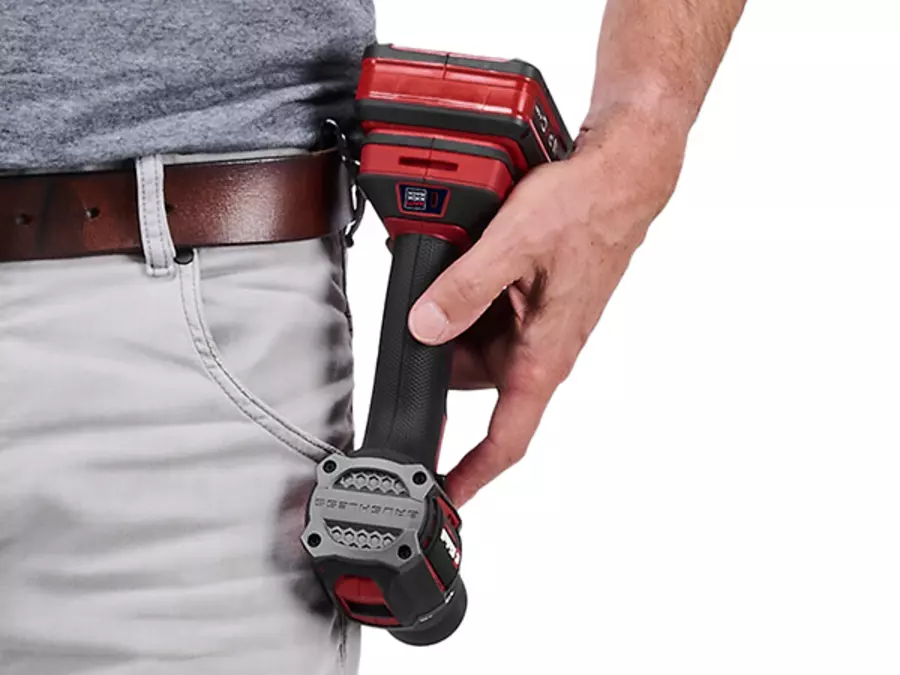 Einhell Professional cordless impact drill TP-CD 18/50-C Li-i BL (2x3Ah) hooked with the metal belt clip onto a person's trousers on a white background.