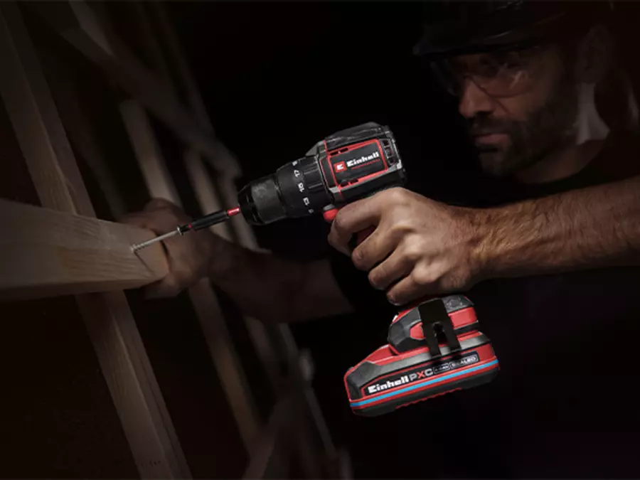 The Einhell Cordless Impact Drill Driver TP-CD 18/70-C Li-i BL - Solo in use in a dark environment with LED light activated.