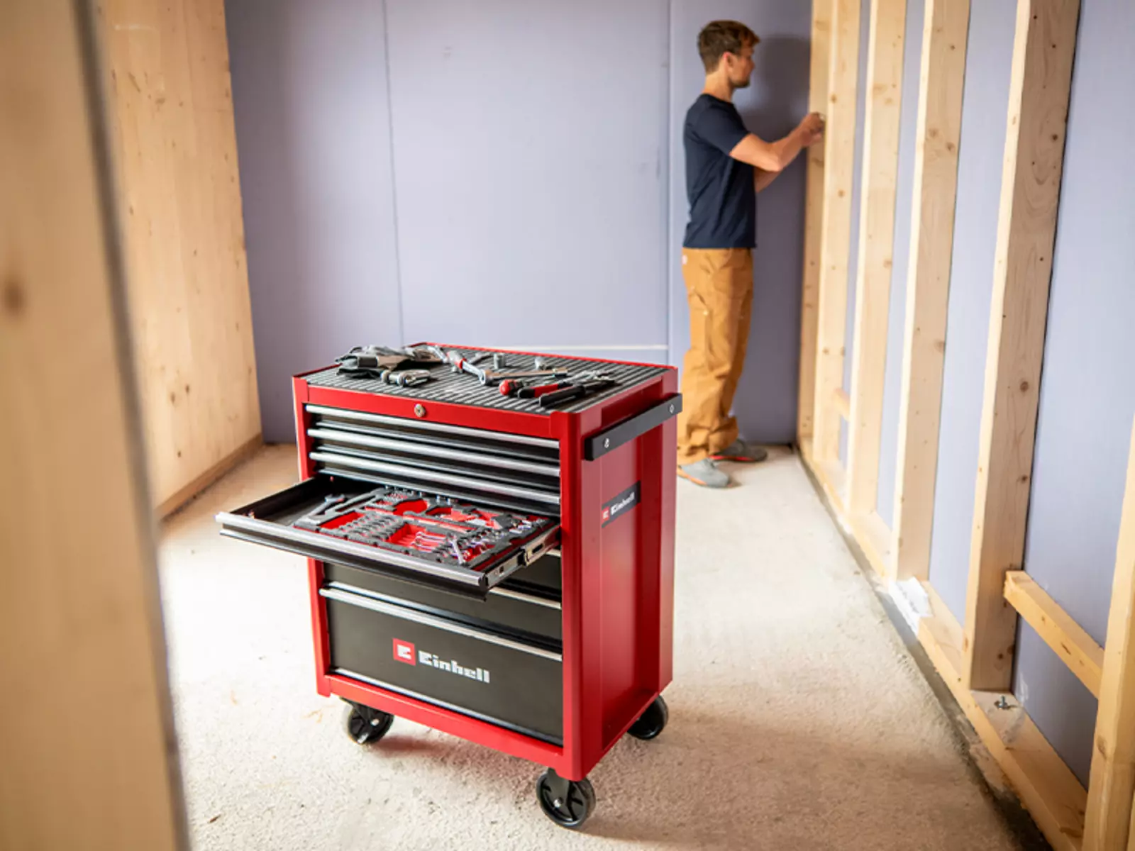 Einhell Werkstattwagen TC-TW 150 mit geöffneten Schubladen und Werkzeug im Einsatz auf einer Baustelle im Innenausbau.