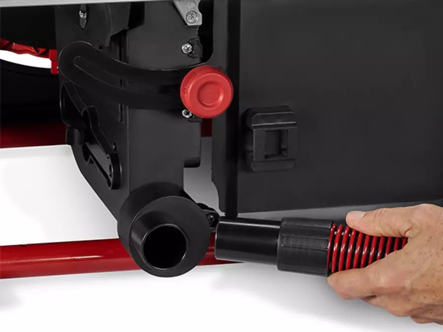 A vacuum hose is connected to the dust extraction port of the Einhell table saw TE-TS 10 T.