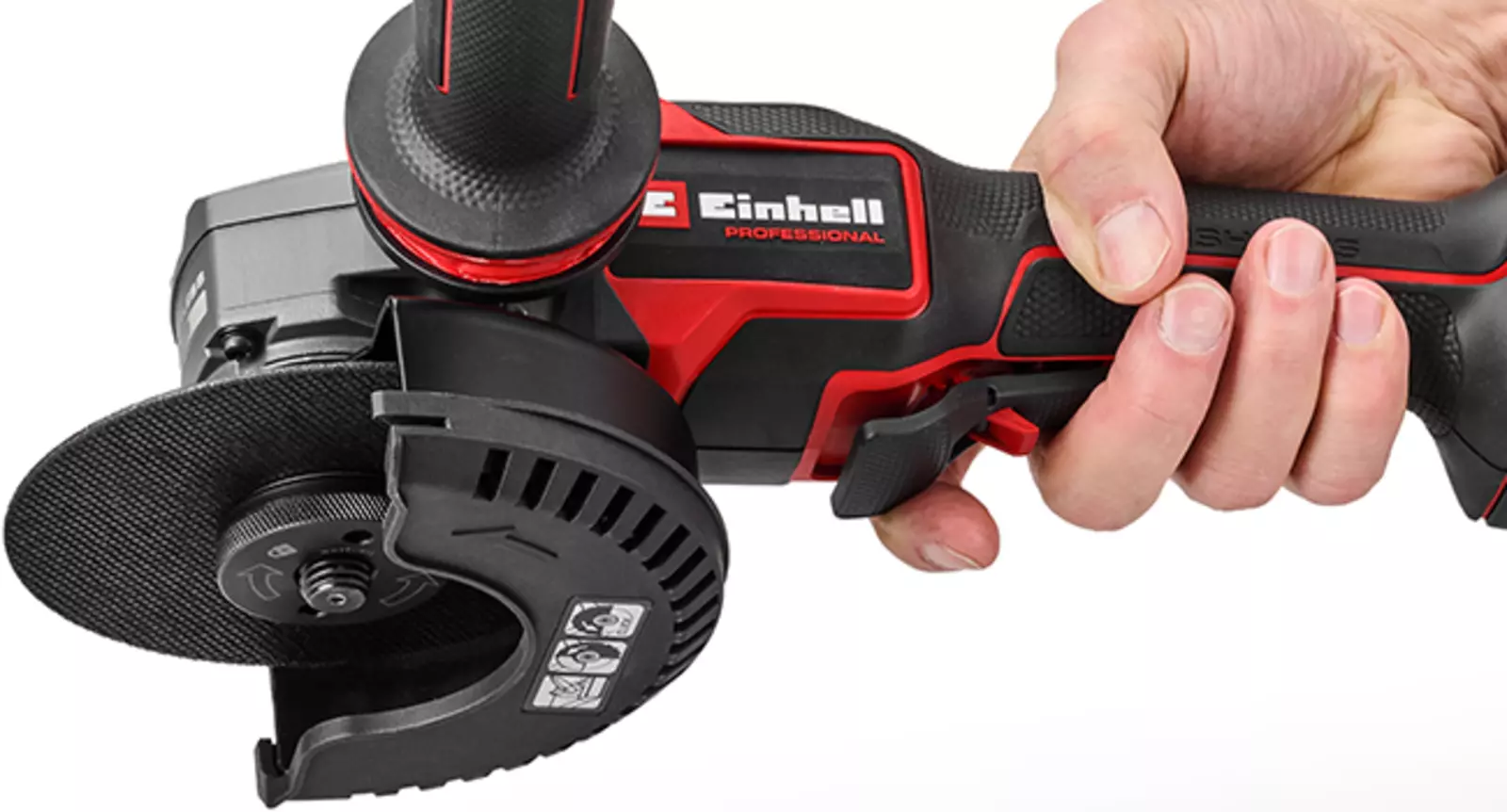 The Einhell Professional TP-AG 18/125-13 Q P BL cordless angle grinder is held in one hand; the large paddle switch is clearly visible.