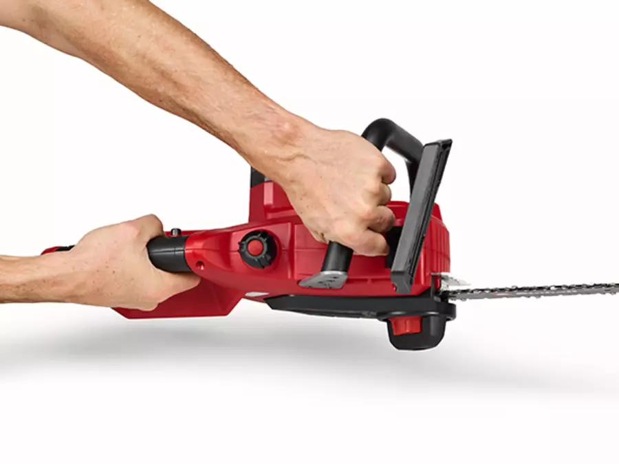 Die Einhell Akku-Kettensäge GE-LC 18/25-1 Li Kit (1x2,5Ah) mit Rückschlagschutz; eine Hand greift den vorderen Griff.