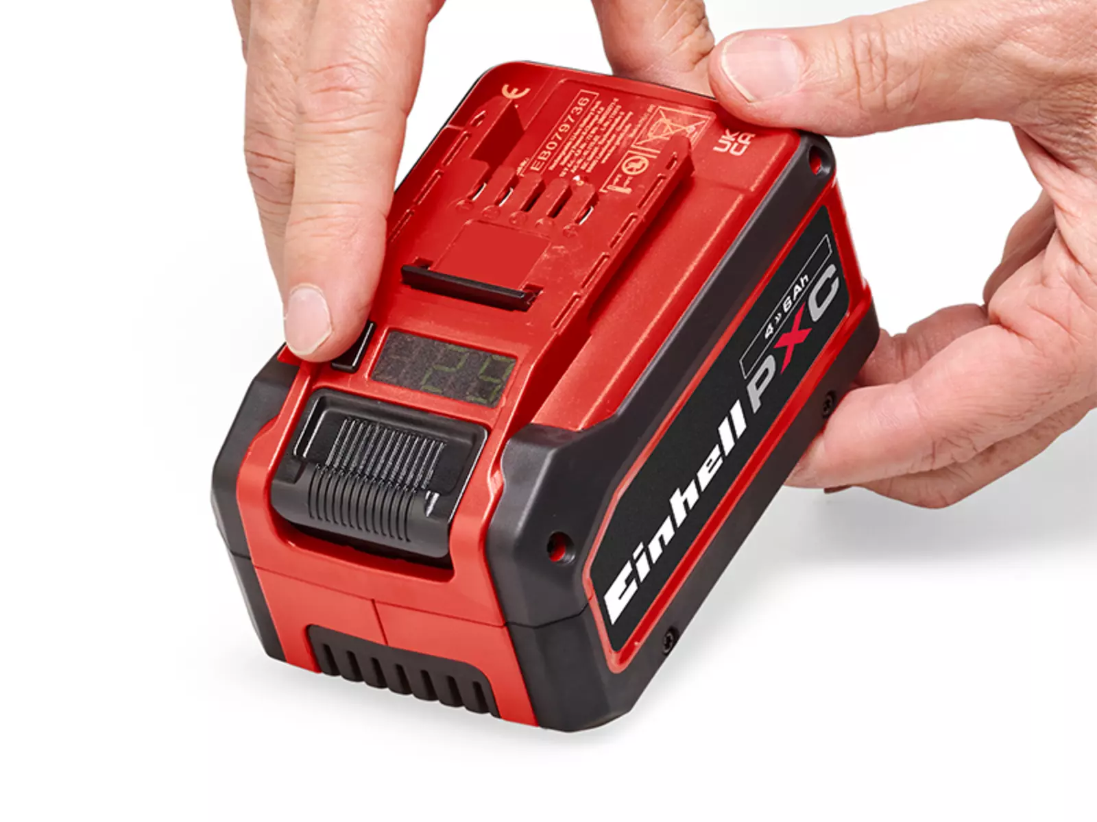 The Einhell Power X-Change battery, a hand presses the button to show the charge level on the display.