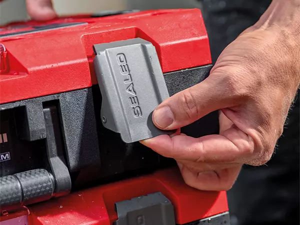 The Einhell E-Case Rolling Workshop SEALED with grey latch clip in close-up, opened by hand.
