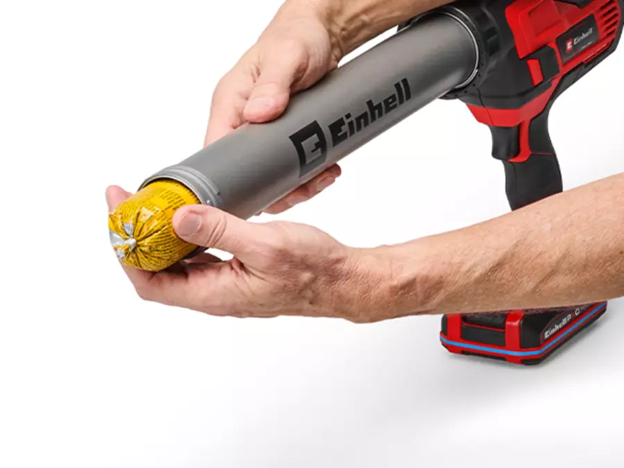 The Einhell cordless cartridge gun TE-SG 18/600 B Li - Solo is used with foil packs, shown held in the hands.