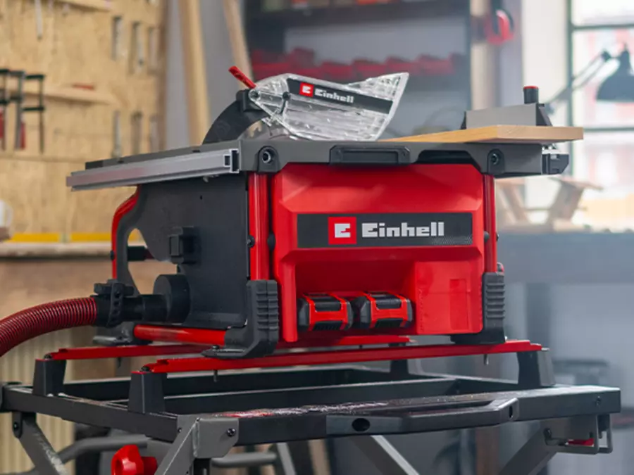 Die Einhell Akku-Tischkreissäge TE-TS 36/8 T Li-Solo im Einsatz in einer Werkstatt; ein Holzbrett wird durchgesägt.