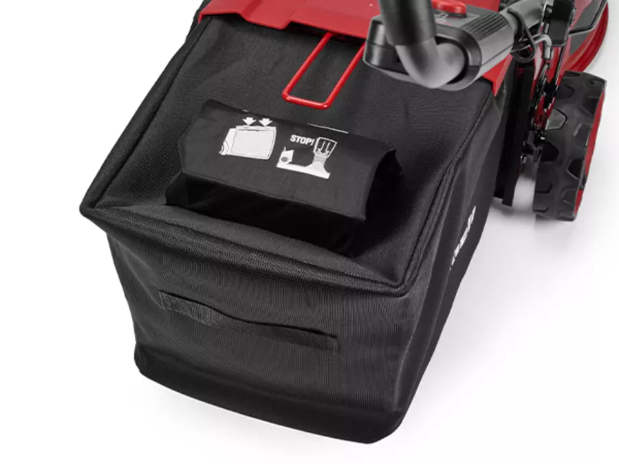 O Einhell corta-relva a bateria da parte traseira com um grande cesto de recolha de relva preto e indicador de nível de enchimento visível.