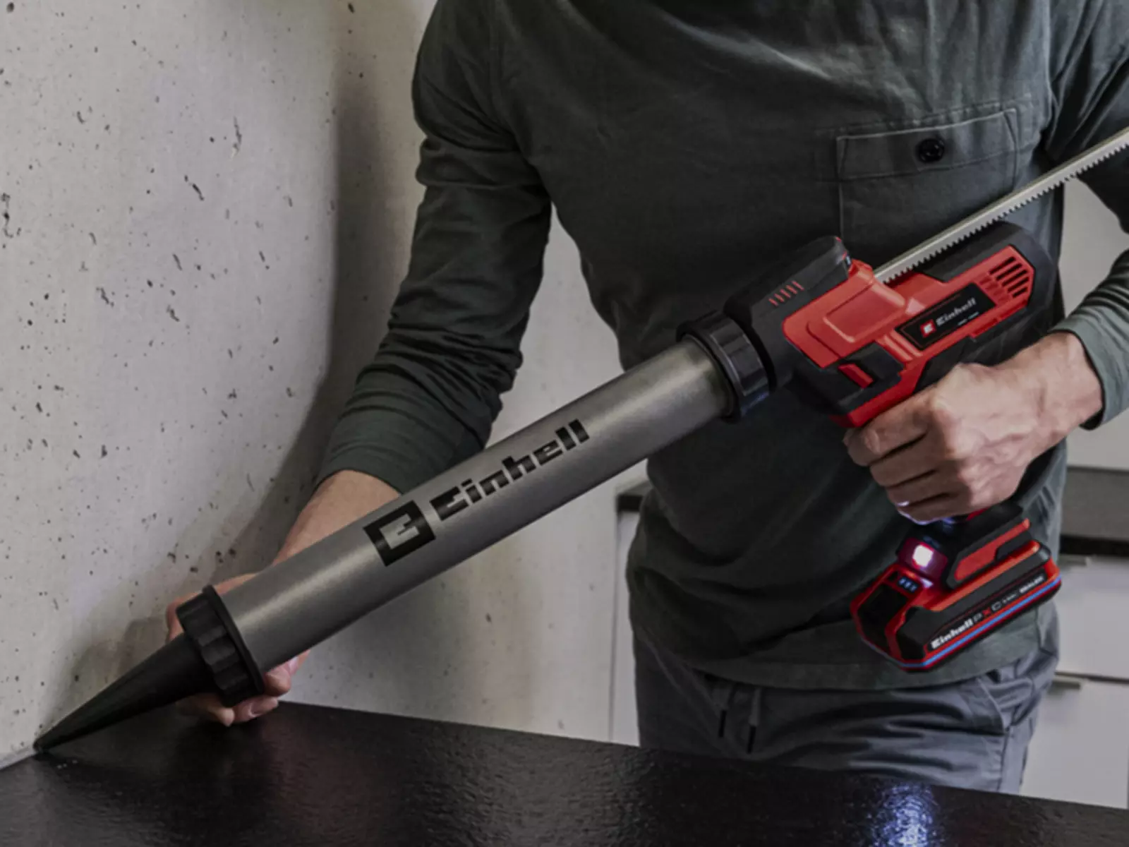 The Einhell cordless cartridge gun TE-SG 18/600 B Li - Solo applisealant along the edge of a wall.
