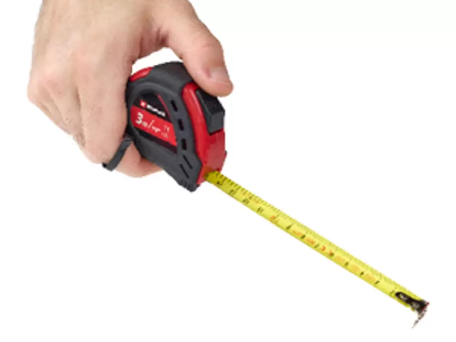 Hand holding a red and black Einhell tape measure with extended yellow measuring tape.
