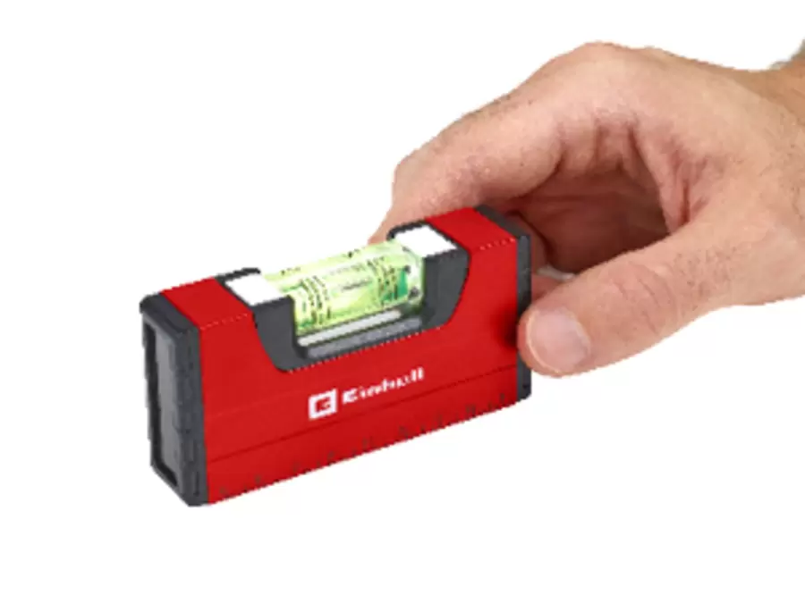 Hand holding a red and black Einhell mini spirit level with a visible vial.