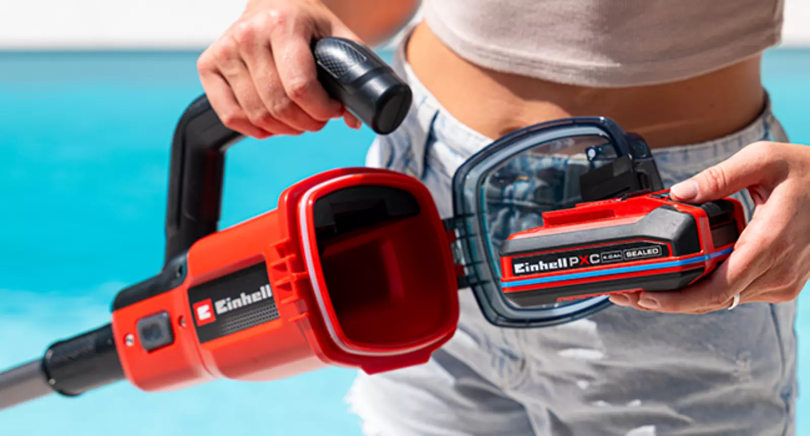 Die wasserdichte Batteriebox des Einhell Akku-Poolsaugers GE-PV 18/42 Li T-Solo wird am Poolrand in der Hand gehalten.