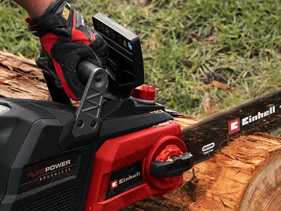 Person operating the Einhell Professional 36V Brushless 400mm Chainsaw in a garden.