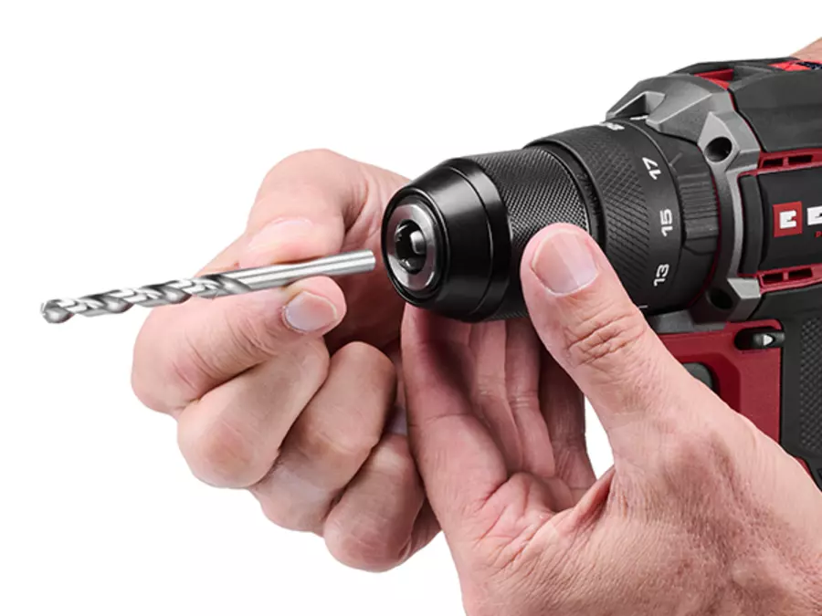 A drill bit is inserted by a hand into the quick-release chuck of the Einhell Professional cordless impact drill TP-CD 18/50-C Li-i BL.
